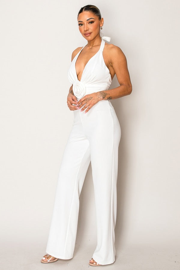Woman wearing a white jumpsuit against a plain background
