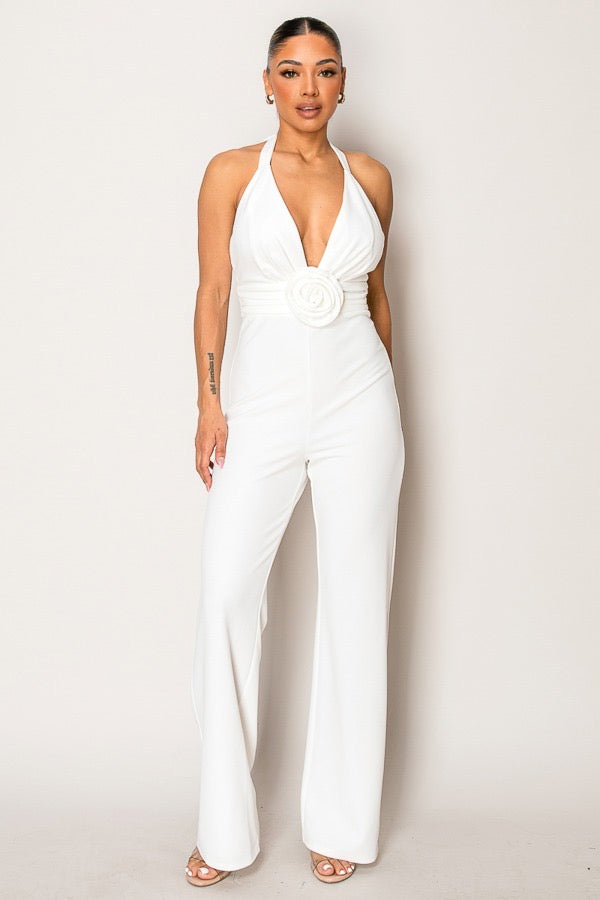 Woman wearing a white jumpsuit against a plain background