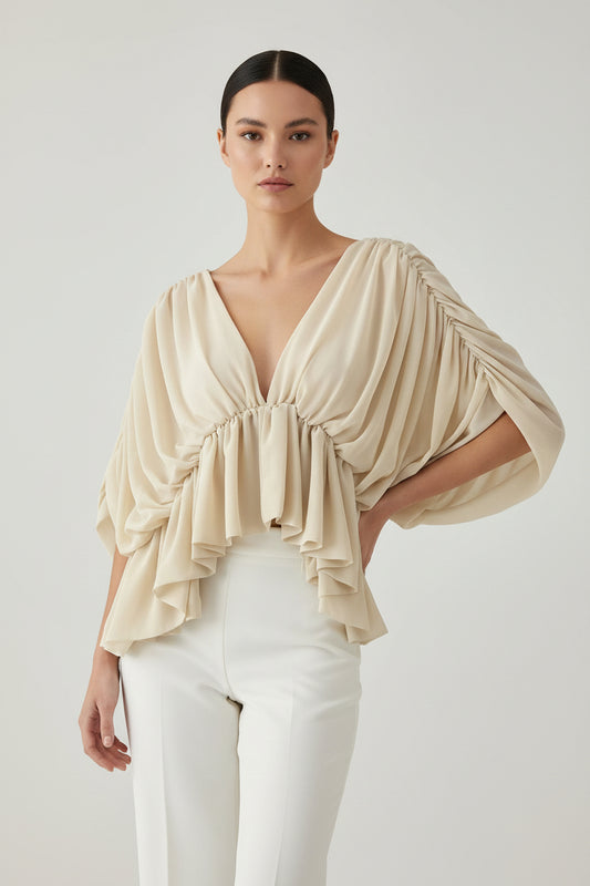 A beige draped off-the-shoulder blouse with a deep V-neckline, gathered elastic details, and cascading ruffles on a solid white background.